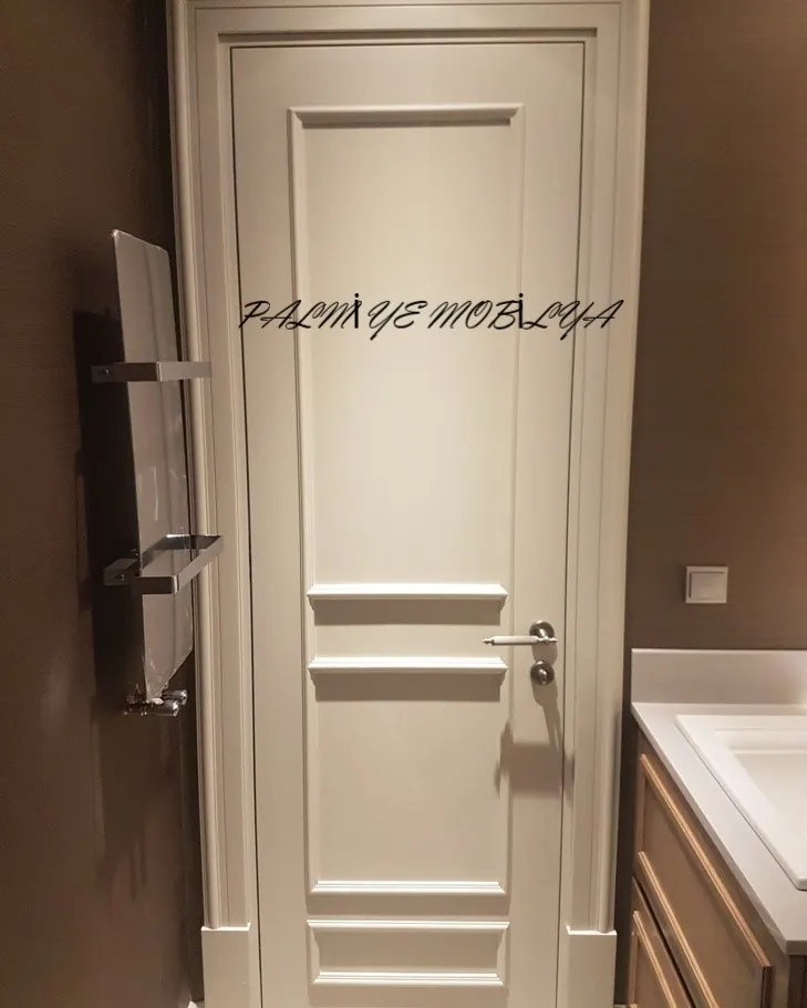 Banyo girişinde havlupan yanında duran krem boyalı panelli ahşap kapı