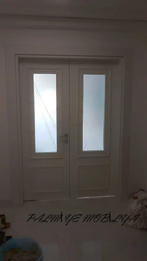 Üst bölümleri buzlu camlı, alt panelleri profilli beyaz çift kanatlı ahşap kapı