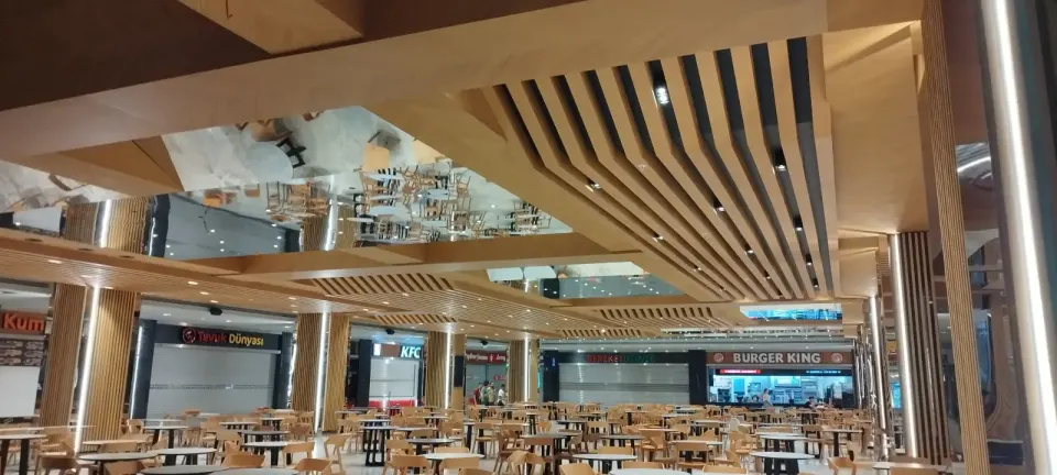 Tezgah sırası boyunca dizilen çıta kaplı kolonlar ve açılı ahşap tavan kirişleri
