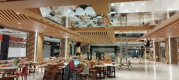 Restoran katında renkli sandalyeler, aynalı tavan ve çıtalı kolonlar arasında son düzenlemeler