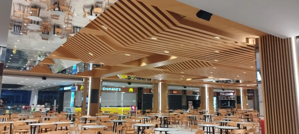 Restoran ahşap dekorasyonunda yemek alanını saran dalgalı ahşap çıtalı tavan ve kolonlar