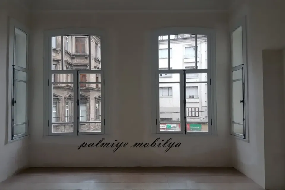 Tarihi binada yenilenen odanın kemerli beyaz ahşap pencereleri ve karşı cephe